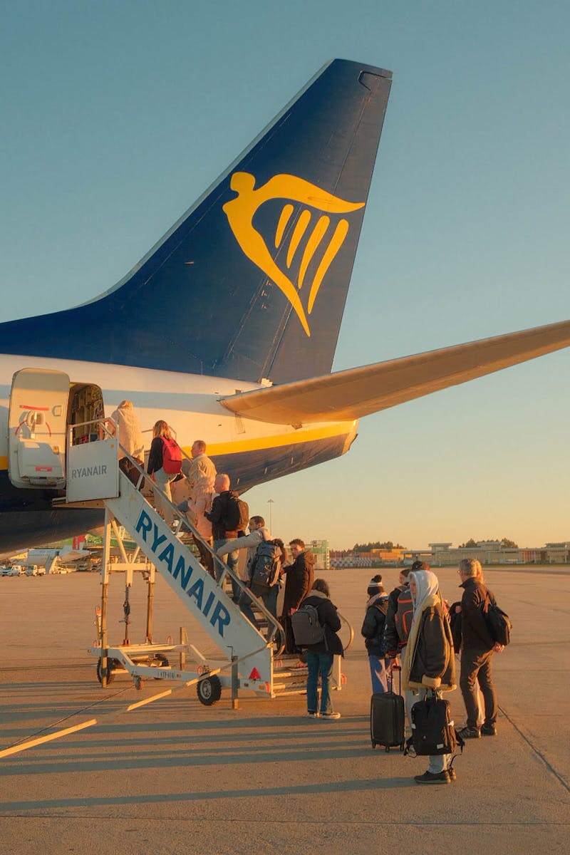 Travelers board a Ryanair plane at sunset in Porto, capturing the essence of budget travel.