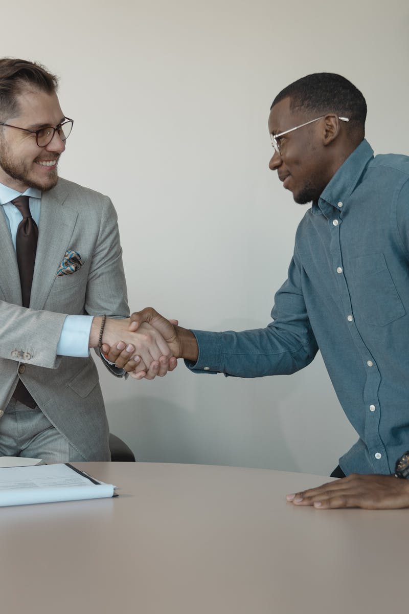 Travels Air touch Two men shaking hands during a professional business meeting in a modern office.